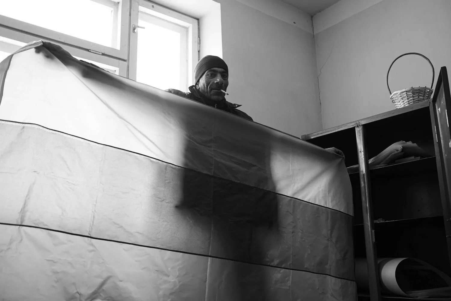 A man met in an abandoned Soviet building displaying the Armenian flag